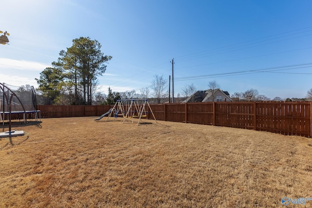 view of yard with a playground and a trampoline