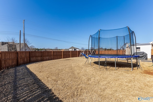 view of yard featuring a playground and a trampoline