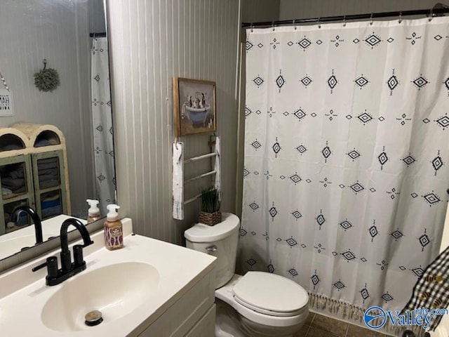 bathroom with tile patterned flooring, vanity, and toilet