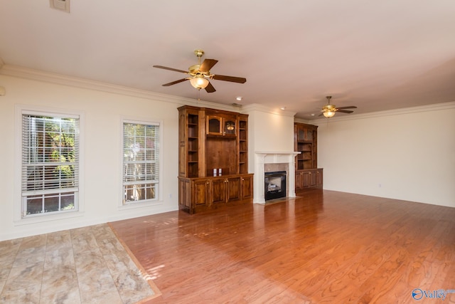 unfurnished living room featuring ceiling fan, wood-type flooring, and crown molding