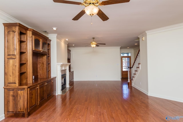 unfurnished living room featuring ceiling fan, dark hardwood / wood-style flooring, and ornamental molding