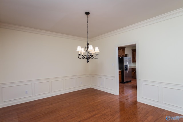 unfurnished room with crown molding, dark wood-type flooring, and a notable chandelier