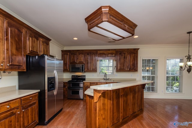 kitchen featuring a healthy amount of sunlight, pendant lighting, light hardwood / wood-style floors, and appliances with stainless steel finishes