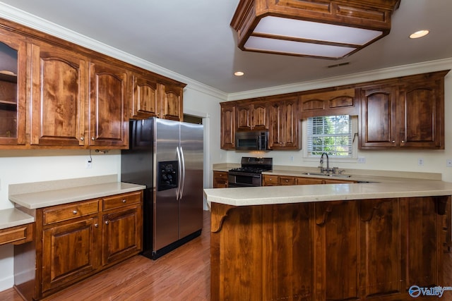 kitchen featuring kitchen peninsula, light wood-type flooring, sink, and black appliances