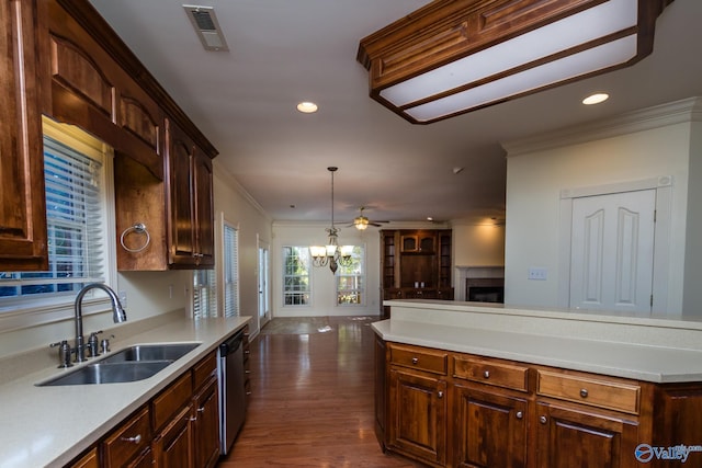 kitchen featuring pendant lighting, dishwasher, dark wood-type flooring, crown molding, and sink