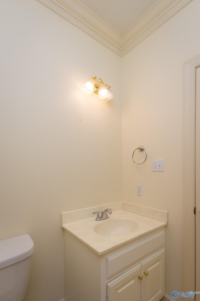 bathroom featuring vanity, toilet, and crown molding