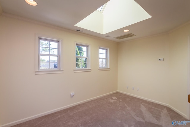 carpeted empty room with a skylight and crown molding