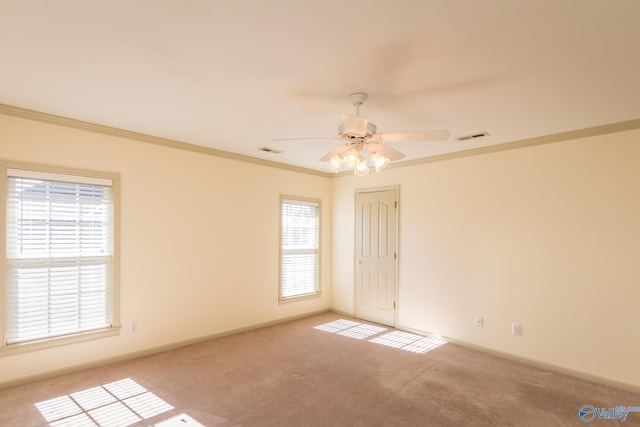 carpeted empty room featuring plenty of natural light, ornamental molding, and ceiling fan