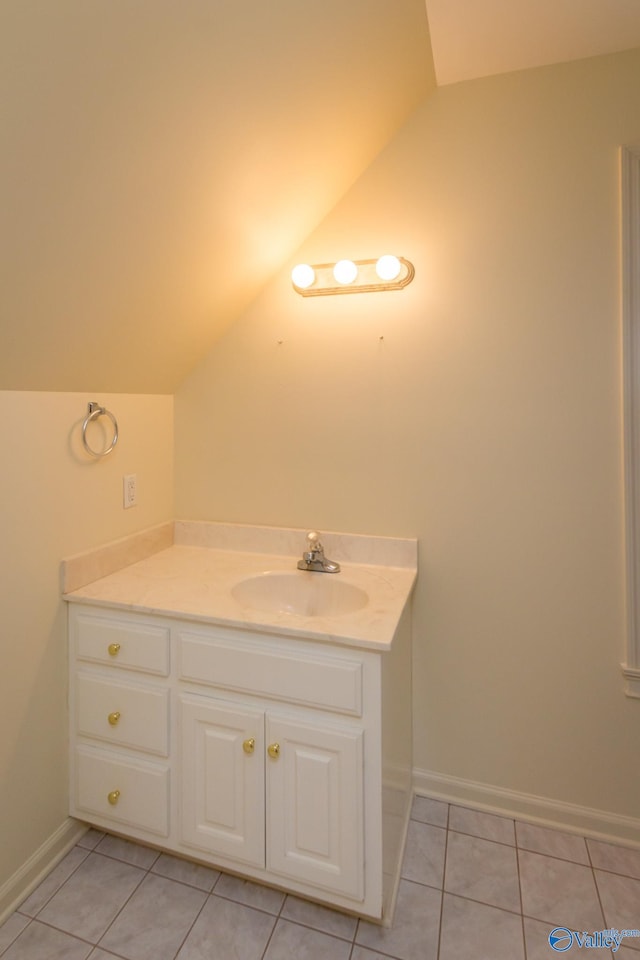 bathroom featuring tile patterned floors, vanity, and vaulted ceiling