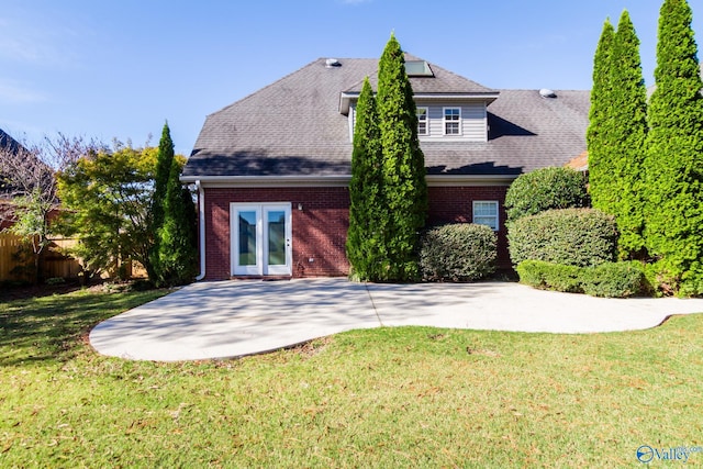 back of property with a yard and a patio