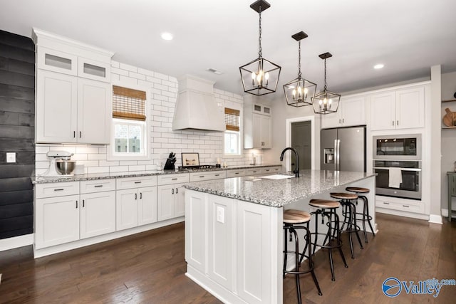 12 Cobbs Cove Way SE, Huntsville, AL 35803 - kitchen featuring appliances with stainless steel finishes, premium range hood, a sink, white cabinets, and backsplash