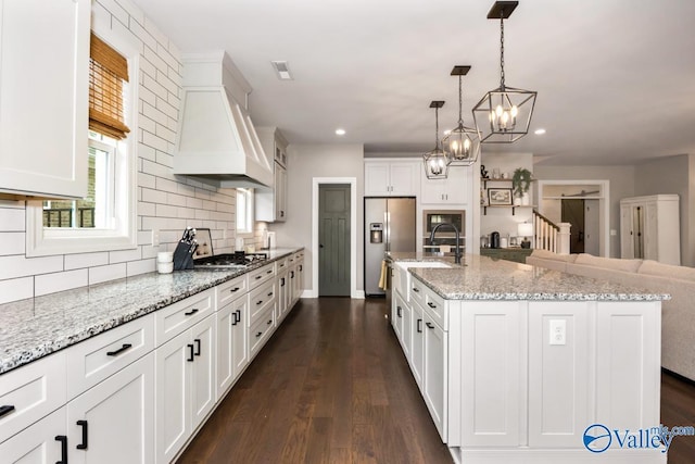 12 Cobbs Cove Way SE, Huntsville, AL 35803 - kitchen featuring appliances with stainless steel finishes, custom exhaust hood, tasteful backsplash, white cabinetry, and a sink