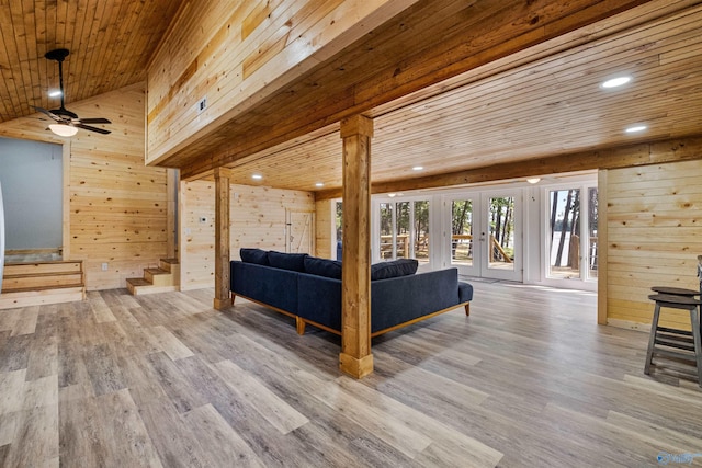 living room with ceiling fan, wooden walls, stairs, wood ceiling, and wood finished floors