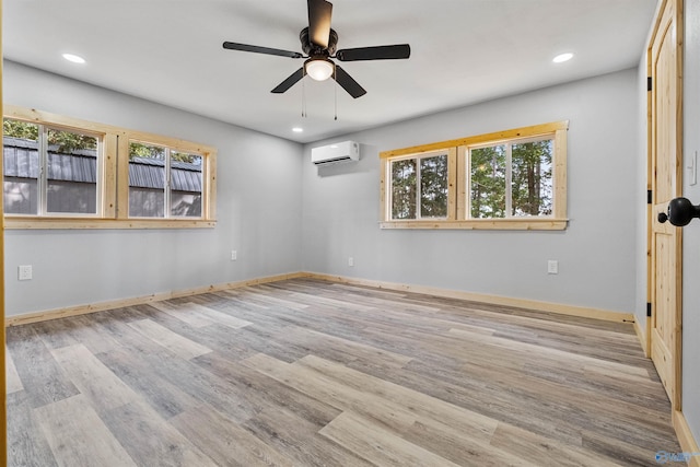 empty room featuring wood finished floors, a wall unit AC, a ceiling fan, and recessed lighting