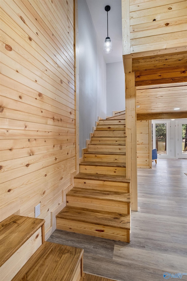 stairway featuring wooden walls and wood finished floors