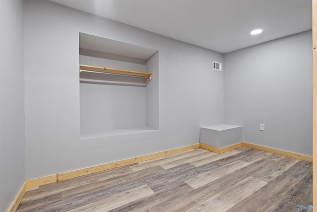 empty room featuring baseboards, visible vents, wood finished floors, and recessed lighting