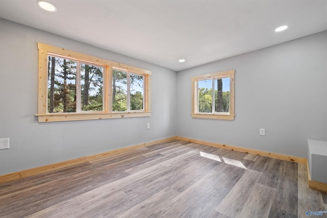 spare room with wood finished floors, recessed lighting, and baseboards