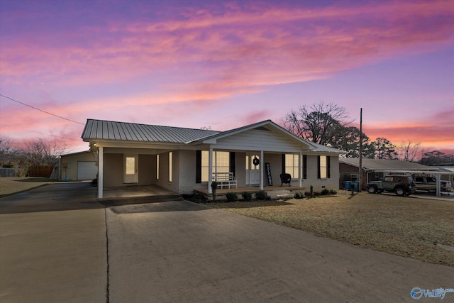 view of front of home featuring a yard, a garage, a carport, and covered porch