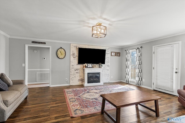 living room featuring dark wood-type flooring, ornamental molding, and a notable chandelier