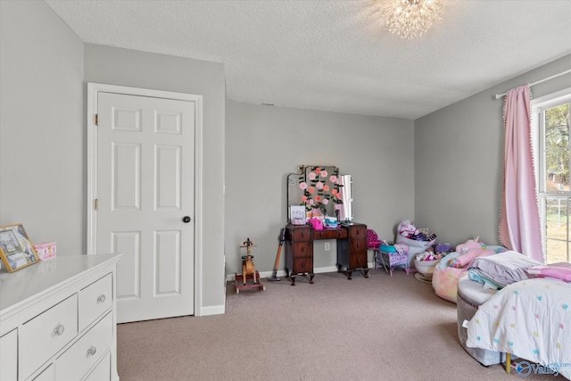 bedroom featuring an inviting chandelier, light colored carpet, and a textured ceiling