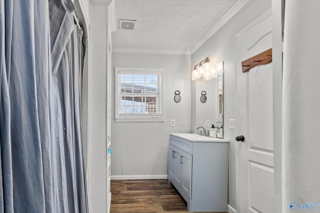 bathroom with ornamental molding, hardwood / wood-style floors, vanity, and a textured ceiling