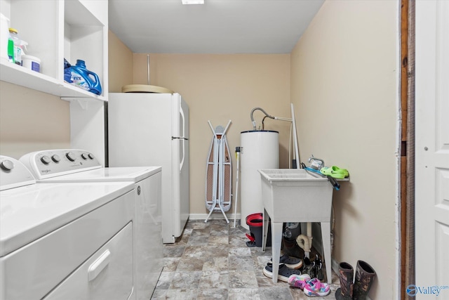 clothes washing area featuring washing machine and dryer and water heater