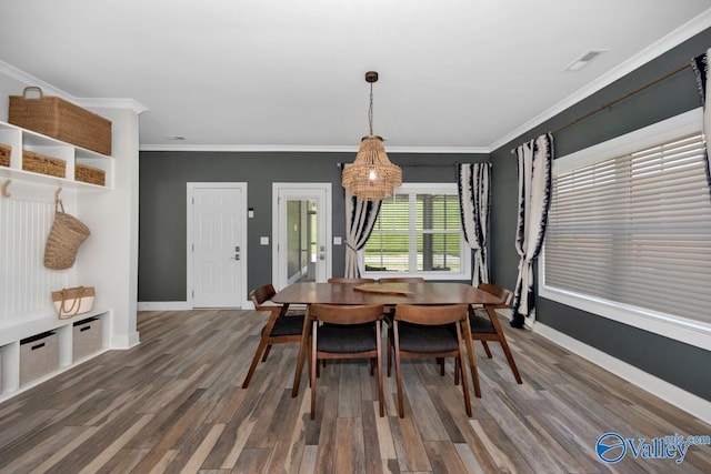 dining area with wood finished floors, crown molding, visible vents, and baseboards
