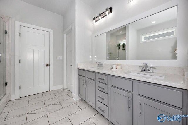 bathroom with marble finish floor, a sink, and a shower stall