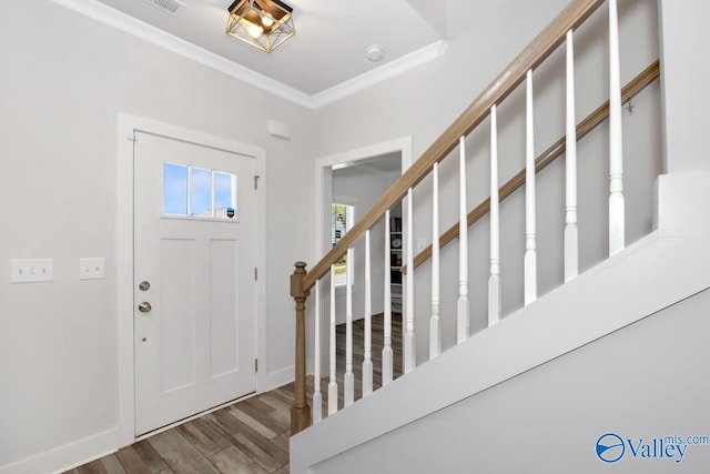 foyer entrance featuring crown molding, stairway, wood finished floors, and baseboards