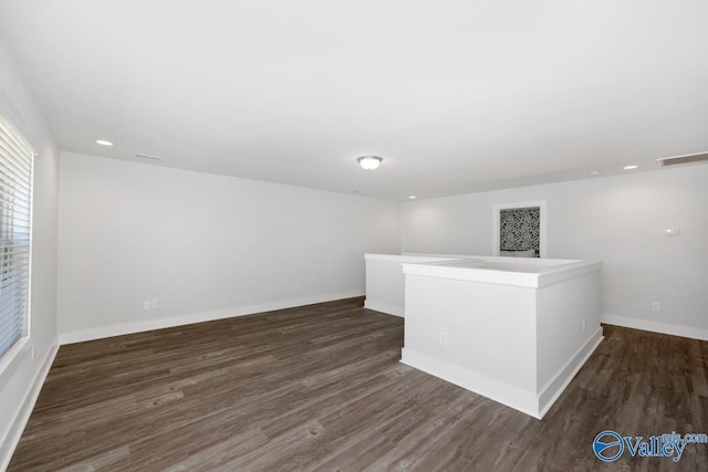 unfurnished room featuring visible vents, wood finished floors, and baseboards
