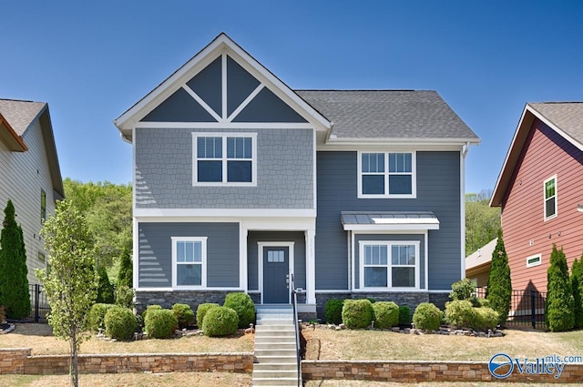 craftsman-style house with fence and stone siding