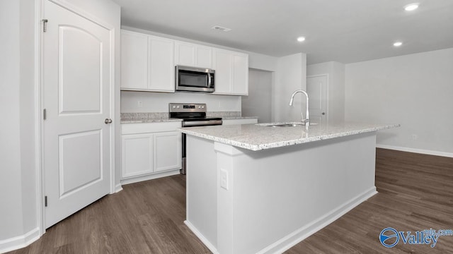 kitchen featuring white cabinetry, dark hardwood / wood-style flooring, an island with sink, and appliances with stainless steel finishes