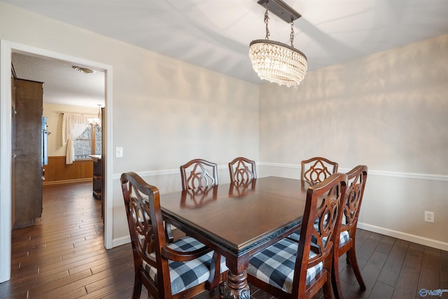 dining room featuring an inviting chandelier and dark hardwood / wood-style flooring