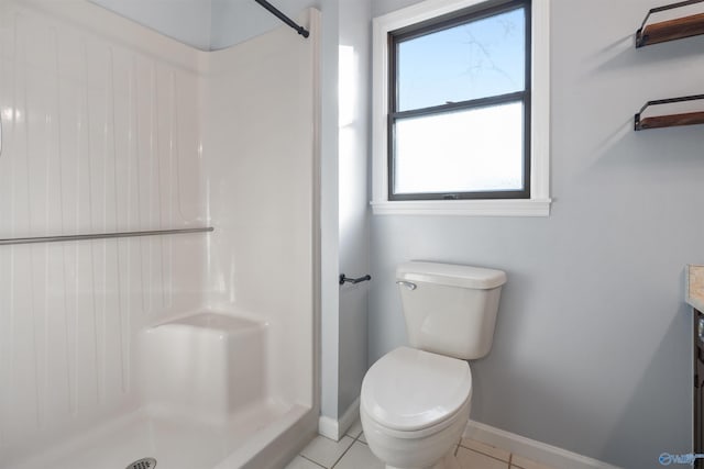 bathroom with tile patterned flooring, a shower, vanity, and toilet