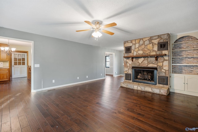 unfurnished living room with a stone fireplace, dark hardwood / wood-style floors, and a textured ceiling