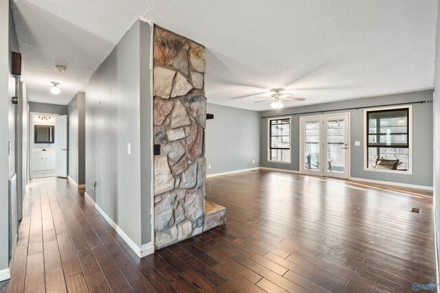 unfurnished living room with dark wood-type flooring, ceiling fan, and a textured ceiling