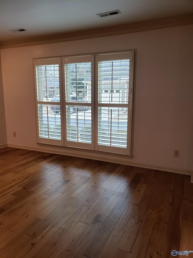 unfurnished room with wood-type flooring and ornamental molding