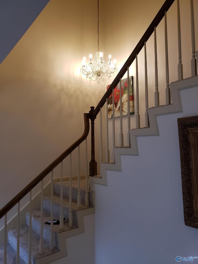 staircase with a chandelier and a high ceiling