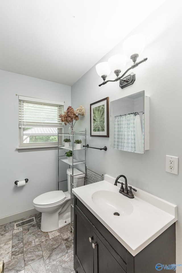 1108 Danmann Dr SE, Huntsville, AL 35803 - bathroom with toilet, vanity, baseboards, stone finish flooring, and curtained shower