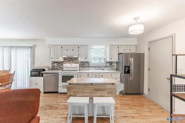 1108 Danmann Dr SE, Huntsville, AL 35803 - kitchen with appliances with stainless steel finishes, light countertops, light wood finished floors, white cabinetry, and a sink