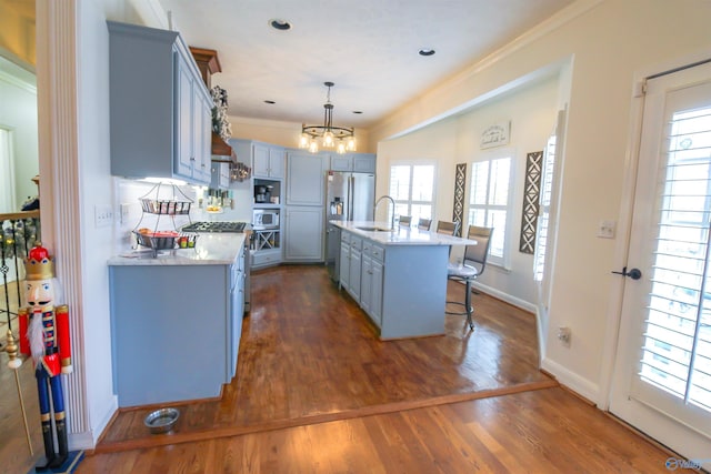 kitchen featuring a kitchen bar, plenty of natural light, an island with sink, and appliances with stainless steel finishes