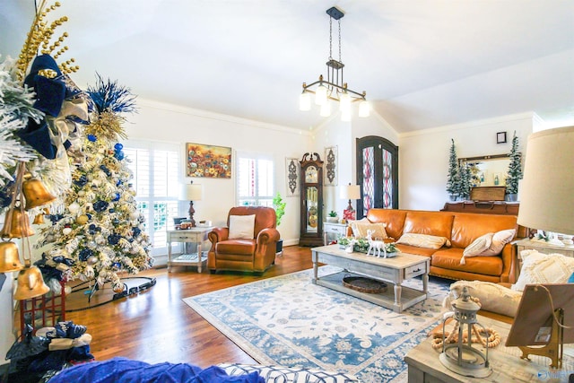 living room featuring a chandelier, crown molding, wood-type flooring, and vaulted ceiling