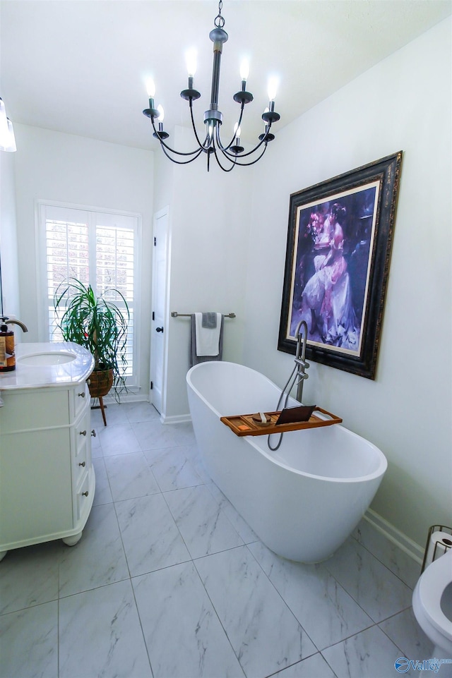 bathroom featuring vanity, a tub, and a notable chandelier