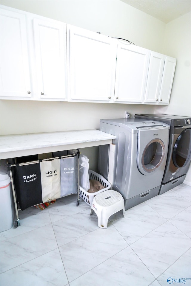 washroom featuring washer and dryer and cabinets