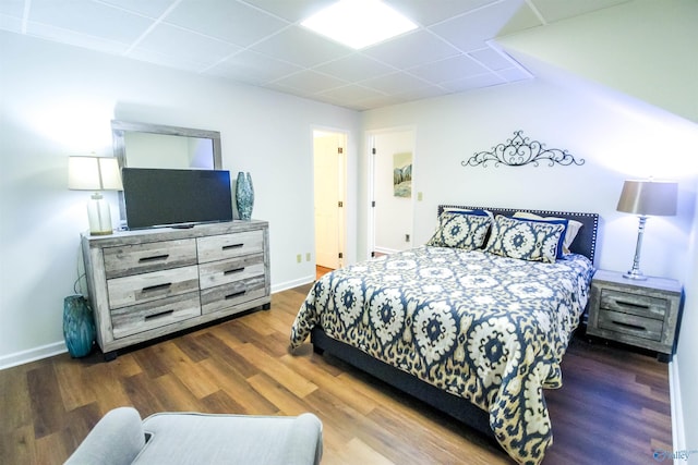 bedroom featuring dark hardwood / wood-style floors and a drop ceiling