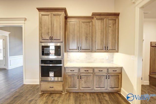 kitchen featuring dark wood-type flooring, stainless steel appliances, and light stone counters