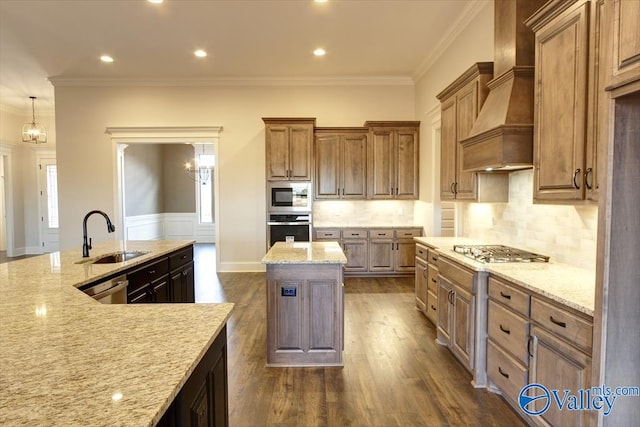 kitchen featuring light stone counters, sink, custom exhaust hood, and stainless steel appliances