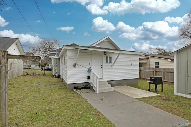 view of front of property with a front yard, fence, and entry steps