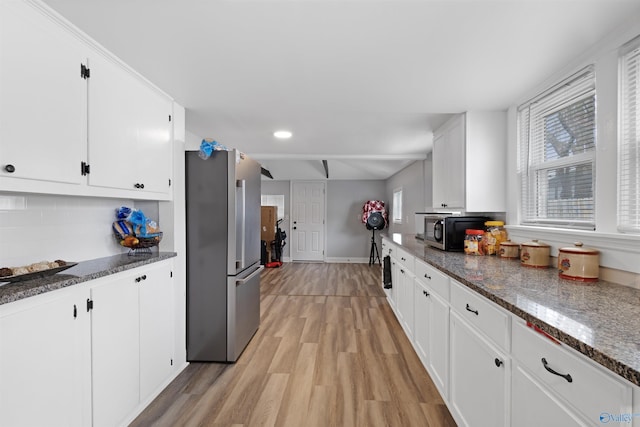 kitchen featuring tasteful backsplash, light wood-style flooring, white cabinetry, and stainless steel appliances