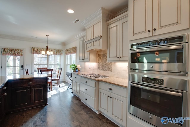 kitchen featuring stainless steel appliances, dark wood-type flooring, visible vents, tasteful backsplash, and crown molding